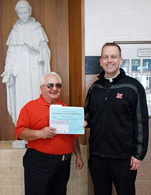 Jerome Svoboda presents a check for the Guardian Angel Fund to Father Sean Timmerman, chief administrative officer of Aquinas and St. Mary Schools in David City. The Knights of Columbus of Holy Trinity Parish in Brainard raised the funds in their 10th annual ‘poker run.’
